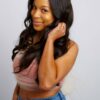weave-closure-long-natural-hairstylist-new-york-yeluchi-53 woman smiling at camera wearing a weave closure hairstyle pulling her hair back with her left hand