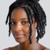 woman smirking at camera wearing two strand Smedium twists with no extensions in a half-up/half-down style